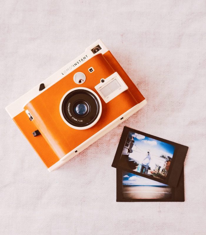 Camera with printed photographs on a desk